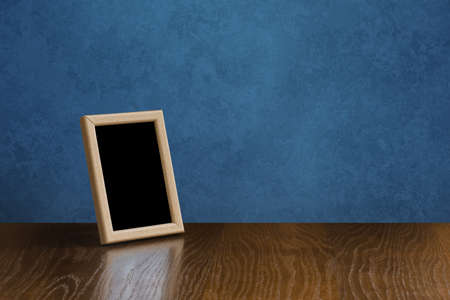 wooden photo frame on table, blue wallの写真素材