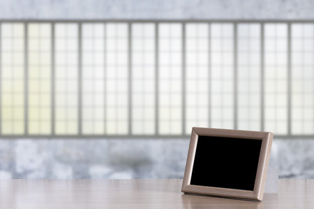 photo frame on the wooden table in the room with big windows