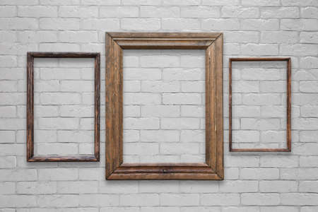 old photo frames on white brick wallの写真素材