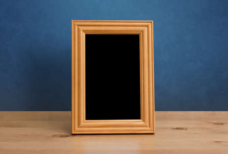 wooden photo frame on table, blue wallの写真素材