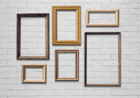 old photo frames on white brick wall