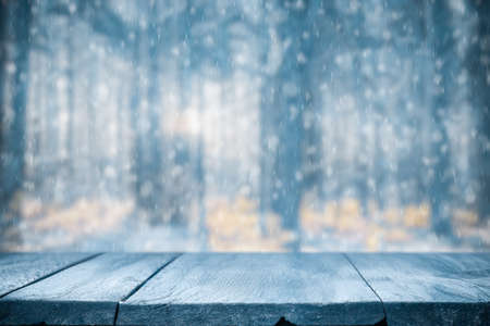 Old frozen wooden table and snowy forest. Christmas and new year winter background.の写真素材