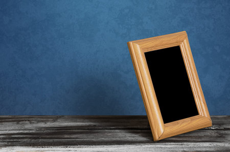 wooden photo frame on table, blue wallの写真素材