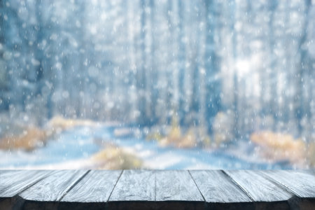 Old frozen wooden table and snowy forest. Christmas and new year winter background.の写真素材