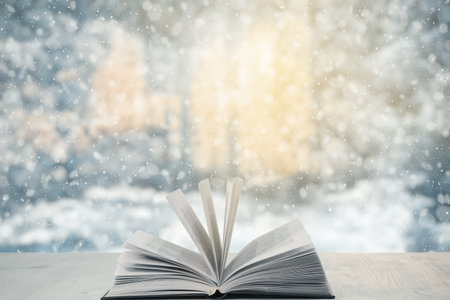 open book on the table, winter woodland background with falling snowの写真素材