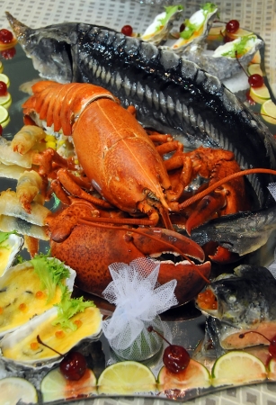 Delicious just-boiled lobster stuffed with sturgeon lying on a wide platter surrounded by mussels with Lemonの写真素材
