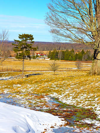 Skiing fields with picturesque background of trees and farmhouses  The snow is melting on the fields of tranquil countryside の写真素材