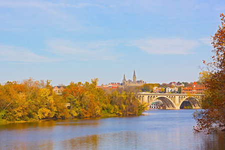 Fall colors of Potomac riverside and Key Bridge, Washington DC. A view on Georgetown University across Potomac River in autumn.の写真素材