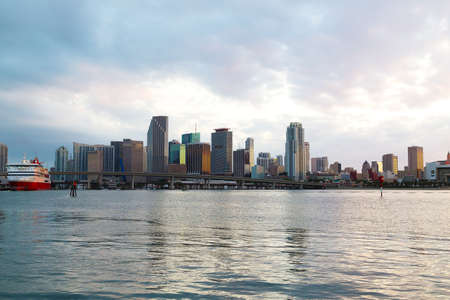 Miami city skyline with bridge and cruise ship at sunset with cloudy sky. Urban panorama of Miami city in the evening.の写真素材