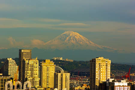 Mount Rainier and Seattle buildings at sunset hours. City view and Mount Rainier with a snow top.の写真素材