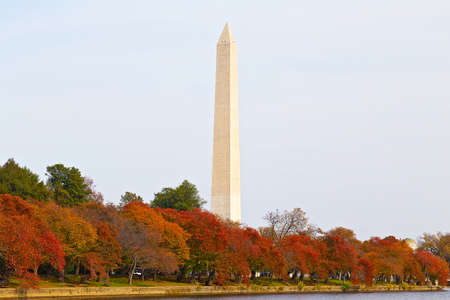 Washington Monument in autumn. The Monument is surrounded by trees in the colorful foliage during the Fall in DC, USA.の写真素材