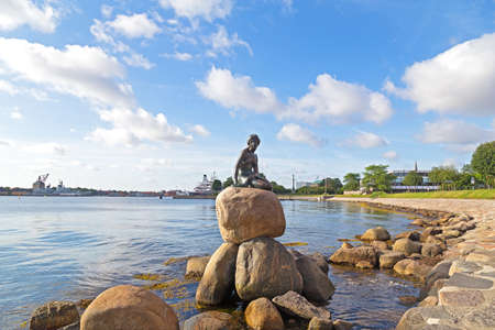COPENHAGEN, DENMARK - JULY 16: The Little Mermaid statue against the cloudy blue skies on July 16, 2014. The bronze sculpture by Edvard Eriksen became one of the city's most famous attractions.のeditorial素材