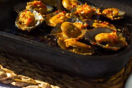 Lapas Ã¢ï¿½ï¿½ appetizer served on islands of Azores archipelago, Portugal. Limpet clams prepared with lemon and served on a frying pan.の写真素材