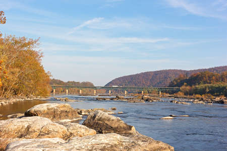 A bridge across Potomac River near Harpers Ferry, West Virginia, USA. Autumn landscape of Blue Ridge Mountains and Potomac River.の写真素材