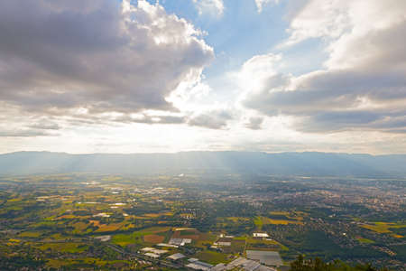 Panoramic view of Swiss Alps near Geneva, Switzerland. Farmhouses and hilly countryside on a cloudy day in summer.の写真素材