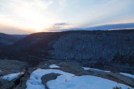 Quiet sunset at Blackwater Falls Park in winter, West Virginia, USA. Horizon over Appalachian Mountains and a road trace in canyon.の写真素材