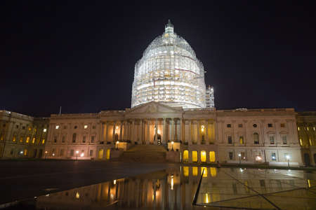 United States Capitol building in Washington, DC at night. The brightly lit dome is covered with scaffolding during comprehensive restoration in 2014-2016.のeditorial素材