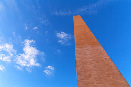 A top part of Washington Monument under the high blue sky. The famous obelisk of the USA is aimed high in the sky.の写真素材