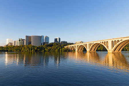 Sunrise over Potomac River with Key Bridge in a view. The bridge and urban skyscrapers as seen from Georgetown Park.のeditorial素材