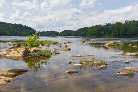 Potomac River near Turkey Island in summer, Virginia, USA. Shallow river waters with rocks on a cloudy day in summer.の写真素材