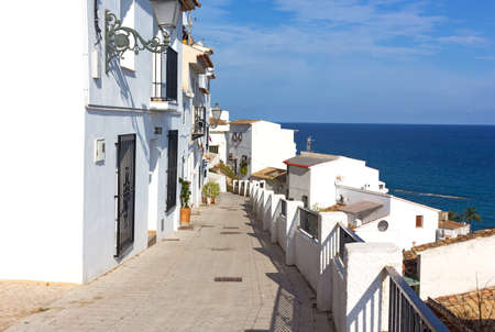 Mediterranean coastal living with sea views in Spain. A road leading to the sea with houses painted in white.の写真素材