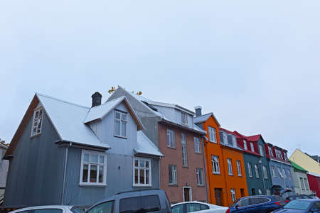 Colorful street buildings in Reykjavik, Iceland. Residential buildings and parked cars on the street.の写真素材
