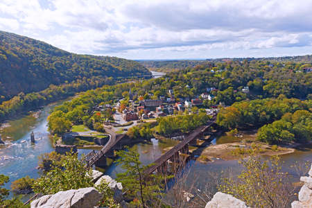 Harpers Ferry historic town and National Park as seen from a high mountain point. Harpers Ferry autumn panorama with railroad bridges across Shenandoah and Potomac rivers.の写真素材
