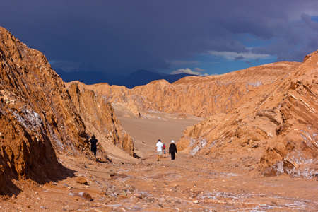Approaching thunder in Atacama Desert, Chile. Tourists explore rock formations and sandy hills on the deserted landscape.のeditorial素材