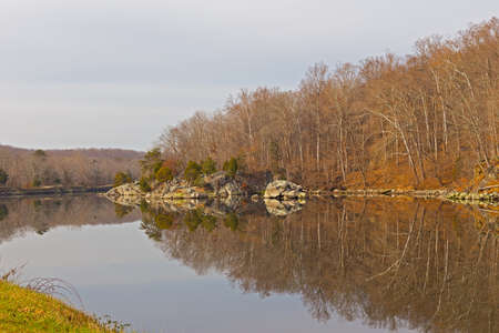 Natural landscape with reflection of trees and rocks near the water. Forest and rocky river bank in the park, Maryland, USA.の写真素材