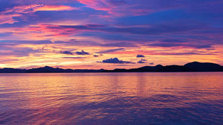 Majestic tropical sunset, Coron Island, Philippines. Sunset over the water with mountain ridges on horizon.の写真素材