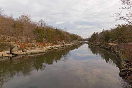 A canal with rocky banks and footpath alongside. Scenic nature landscape in the park, Maryland, USA.の写真素材