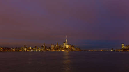 Low Manhattan skyline at night with reflection in Hudson River. Metropolis urban landscape in winter, New York, USA.の写真素材