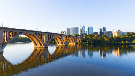 Key Bridge over Potomac River with urban skyscrapers on early morning in Washington DC, USA. A view on the bridge and city development from Georgetown Park neighborhood of US capital.の写真素材