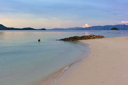 Tropical island paradise, Coron Island, Palawan Province, Philippines. Tranquil lagoon landscape with sandy beach and mountains backdrop on horizon at sunrise.の写真素材