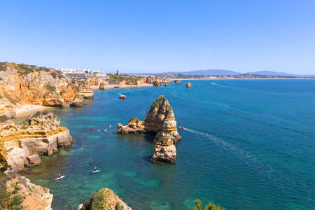 Panoramic view on water sport activities in turquoise sea waters of Lagos, Portugal. Cliffs and Atlantic beaches near Ponta de Piedade in Algarve region offers magnificent vistas, amazing grottoes and caves to explore.の写真素材