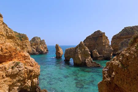 Rocky cliffs and grottoes in Algarve, Portugal. Cliffs and turquoise sea waters on a warm spring morning.の写真素材