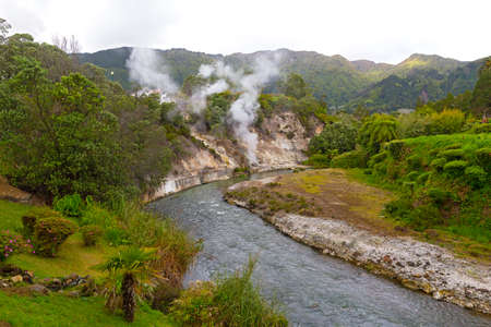 Fumaroles along a waterway created by springs in central part of Furnas village on Sao Miguel Island, Azores, Portugal. Diverse lush flora in area of the easternmost of three active trachytic volcanoes on the island.の写真素材