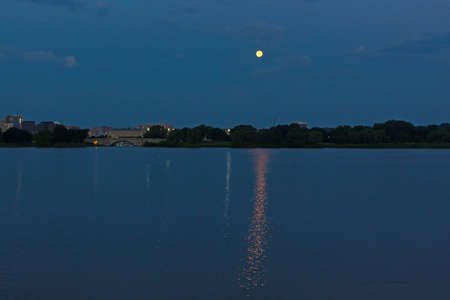 Panoramic scene of Washington DC metro area along Potomac River with the full moon. A view on marina with moored yachts and buildings of Arlington suburb of Virginia at dawn.の写真素材