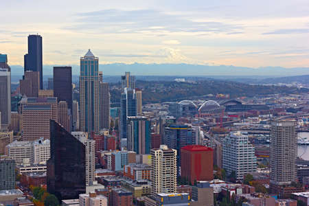 A view on Seattle downtown and Mount Rainier at autumn sunset. Urban panorama with mountain ridges and distinctive peak of Mount Rainier on horizon in Seattle, USA.のeditorial素材