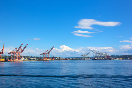 Port panorama on a sunny afternoon in Seattle, USA. Cranes, vessels and cargo containers of the city port.の写真素材