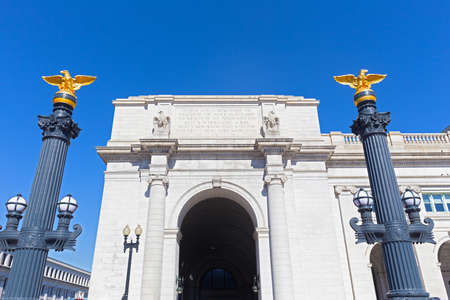 Decorative columns with eagle statues on top in front of the Union Station in Washington DC, USA. Left wing of the Union Station in US capital city under blue skies.の写真素材
