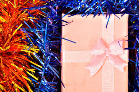 Pink Christmas gift with ribbon on colorful  decorationsの写真素材