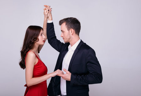 A pair of young people in love dance together a waltz. A girl in a red dress is dancing with a guy...