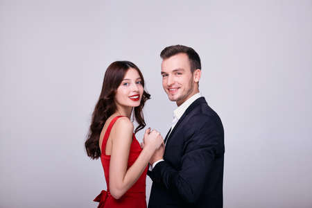 Couple Fashion Beauty, Young Woman in Sexy Red Dress and Embracing Man in Love. A young couple hugs and celebrates the new year. Lovers on Valentine's Day.の写真素材