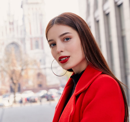 A stunning young and unsurpassed girl with dark blue eyes, large round earrings and a stylish juicy...