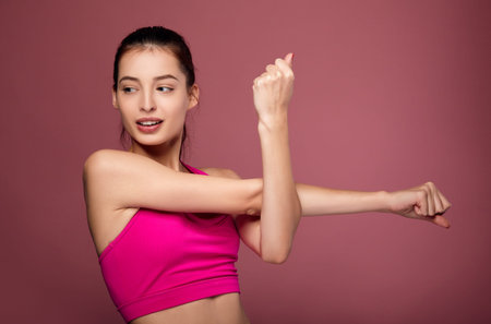 A woman with dark hair and a gorgeous figure is engaged in sports, gymnastics. A sporty lady in a...
