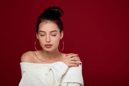 Attractive young white woman in love with brown hair, white clean skin, in a knitted white sweater...