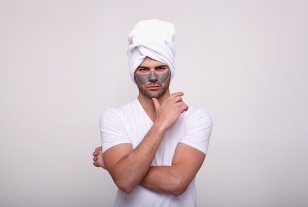 Frustrated angry unhappy sad man isn't atisfied with a mask. Close up photo. Man doesn't want to care of his face. Image of an excited beautiful white couple standing on a gray background. Copy space.の写真素材