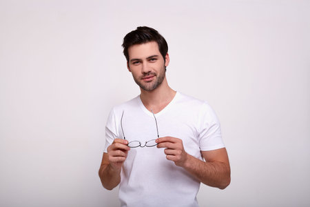 Serious confident bearded male with pleasant appearance, looks with mysterious expression at camera,...
