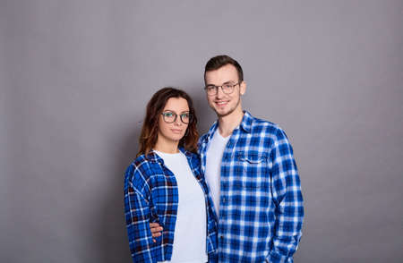 Romantic couples in love meet, hug, look at each other positively, feel support, walk together. Loving couple posing on a gray background. Relationship concept. Copy space.の写真素材